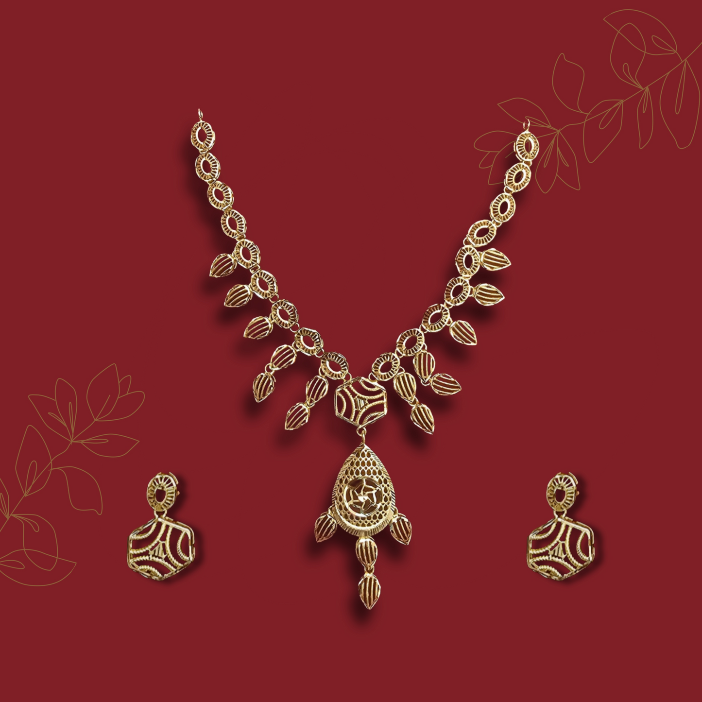 Gold necklace and earrings on a red background with leaf designs.